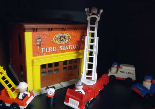Vintage Fisher Price fire station with fire trucks, ladder truck, ambulance, police car