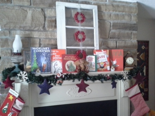 Our fireplace mantel, decorated with greenery and vintage Christmas children's books.